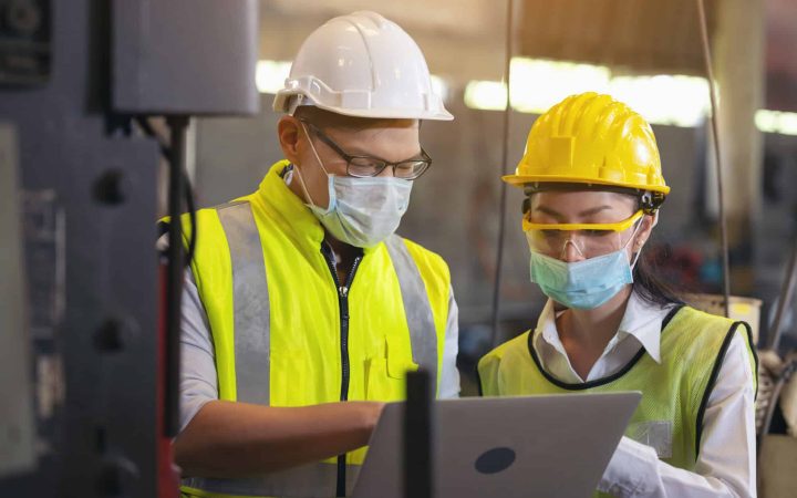 Two,Engineer,In,Hard,Hat,Wearing,Safety,Using,Laptop,For